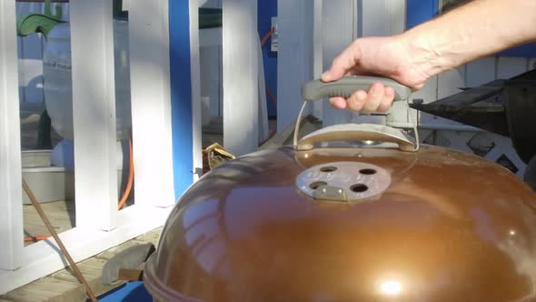 Lifting the lid on a BBQ showing tri-tips cooking