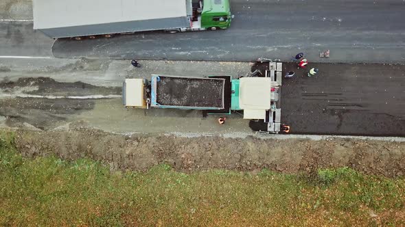 Construction work for road. Pavement machine laying fresh asphalt during highway construction