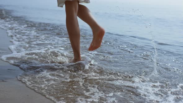 Bare Woman Legs Jumping on Sea Waves Close Up