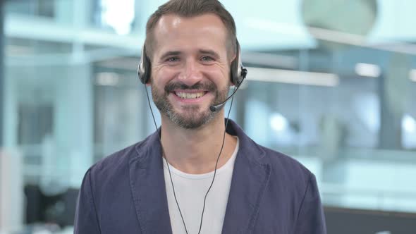 Middle Aged Businessman with Headset Smiling At Camera