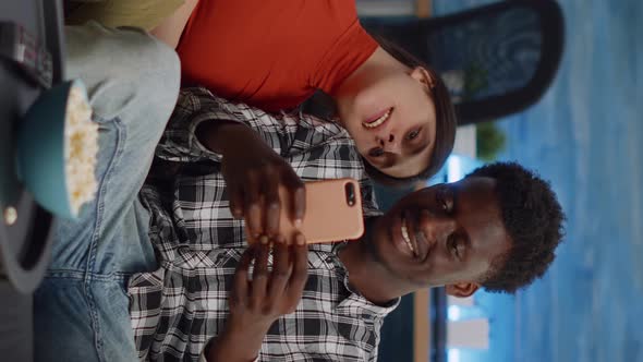 Vertical Video Joyful Interracial Couple Taking Selfies with Smartphone