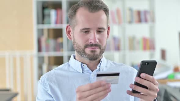 Portrait of Online Payment Success on Smartphone By Man