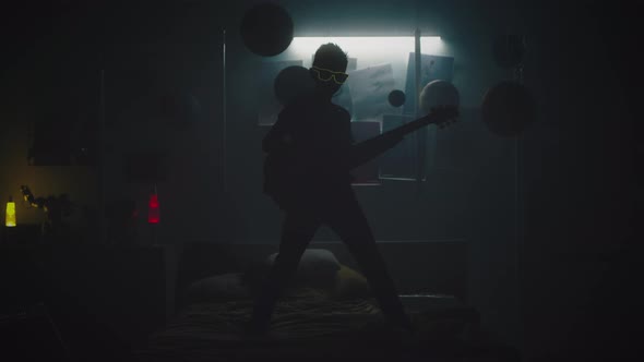 Teen Guitarist Under Colorful Illumination