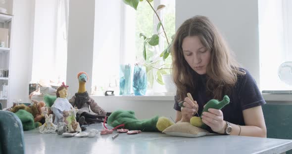 Woman Making Wool Art Doll Toy at Table. Female Sitting and Creating Ooak Doll at Home. Needle