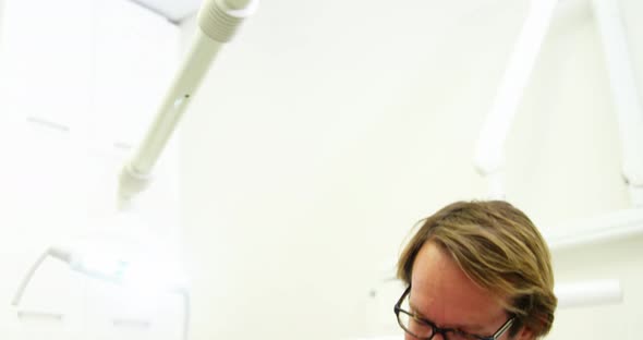 Dentist examining a young patient with dental tools