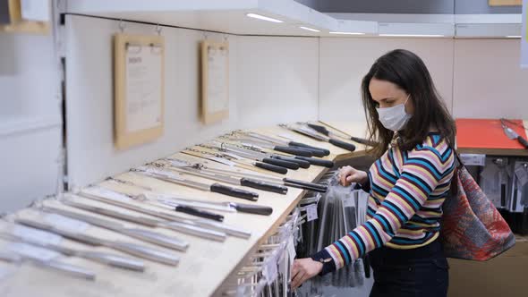 Woman Choosing Kitchen Knife in Furniture Store