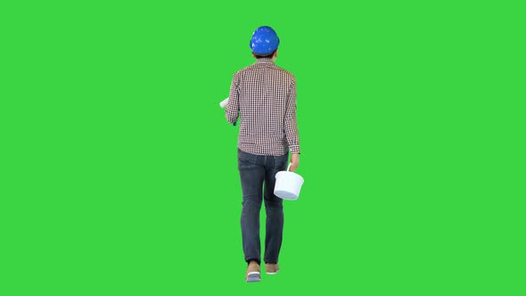 Worker in Hard Hat with Paint and Brush Walking and Looking What to Paint on a Green Screen Chroma