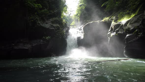 Caucasian Guy Jumps and Swim in the Tropical Rainforest Waterfall at Summer Day