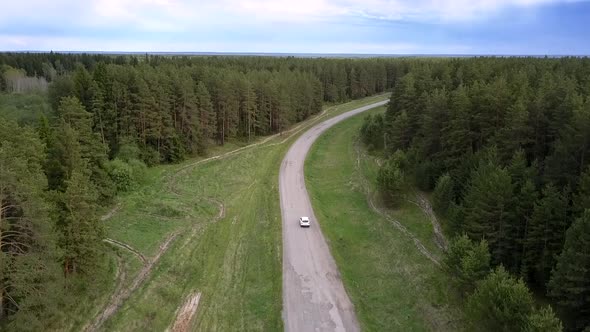 Modern White Automobile Drives Along Winding Road Upper View