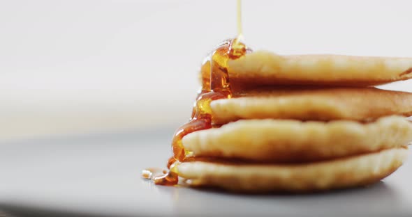 Video of pancakes with maple syrup on white plate seeing from above