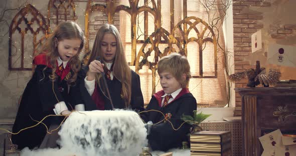 Older Student is Teaching Little Ones How to Brew a Potion in a Steaming Pot