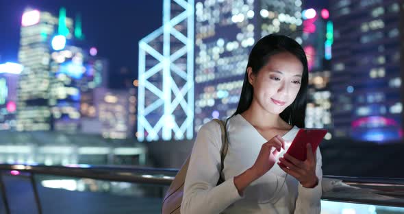 Woman use of mobile phone in city at night