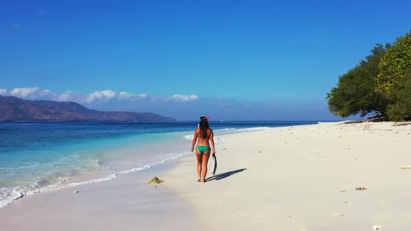 Ladies posing on idyllic coast beach break by blue sea with white sandy background of Gili Trawangan