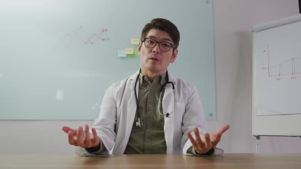 Portrait of asian doctor talking on video call looking at the camera