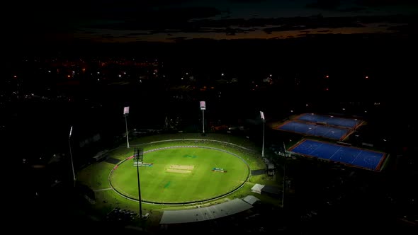 Aerial pan of sports grounds with games being played under lights. Tauranga New Zealand.