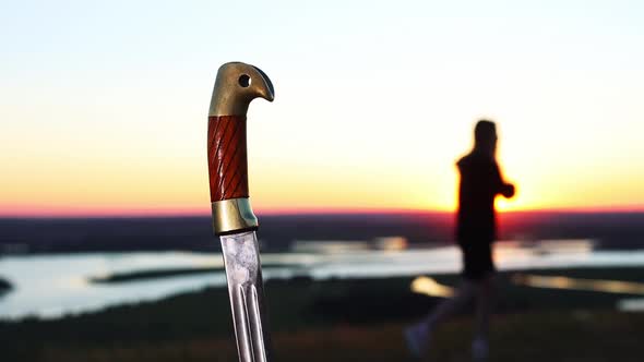 Swords Training  Young Woman Training on Nature While Sunset  Sword Handle on the Foreground