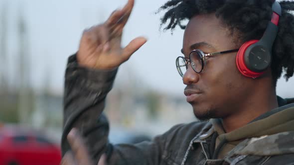 Headshot Portrait of Carefree Young African American Man in Headphones Dancing and Gesturing