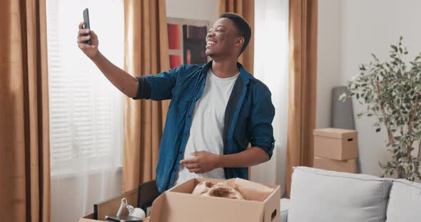 Handsome Guy Hangs Out in New Apartment After Movein Unpacks Cardboard Boxes of Packed Stuff Writes