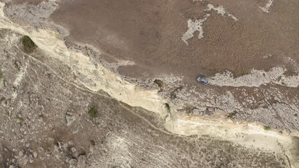 Suv Car Dangerous Riding on Peak Edge of White Cliff Near Abyss Shot