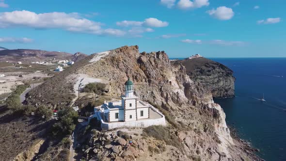 4k aerial drone view of beautiful lighthouse Santorini Greece blue sky with clouds