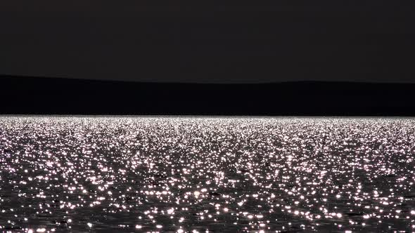 Light Glitters on Surface of Lake Waters at Night