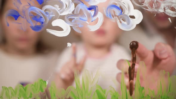 Mom, dad and baby draw temporary images on glass with paints. Selective focus