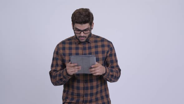 Happy Young Bearded Indian Hipster Man Using Digital Tablet