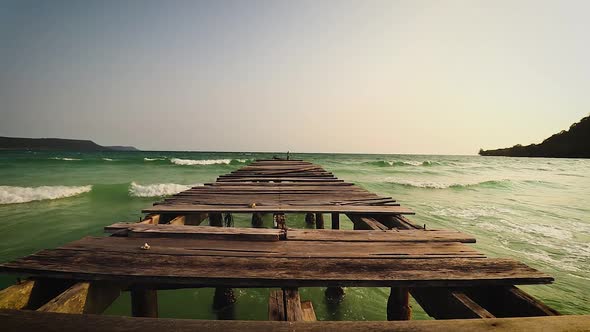 A broken wooden pier facing the open sea at Soksan Beach in Koh Rong Island in Cambodia which is a p