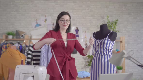 Portrait of a Young Woman Fashion Designer Wearing Glasses with a Measuring Tape