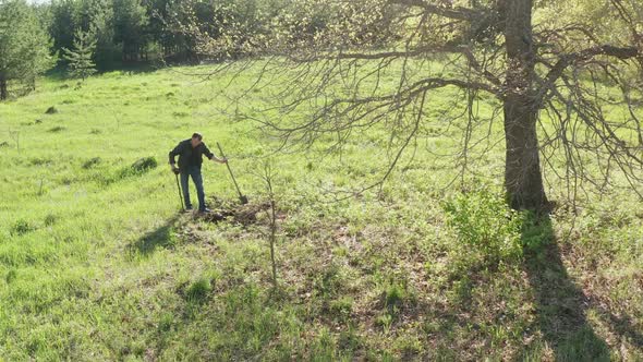 A Man Is Looking for Metal with a Metal Detector. A Guy with a Metal Detector Is Looking for a