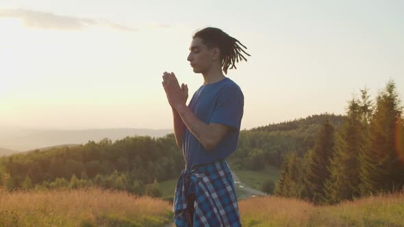 Peaceful Handsome Arab Man Meditating in Prayer Yoga Pose on Mountain Top at Daybreak