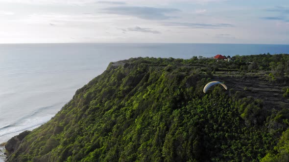 Paraplane, Paraglider In The Air Aerial Shot. Extreme Man Flies On a Paraglider Over a Cliff Near