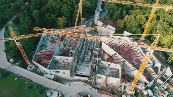 Aerial View Construction of a New Building with High Tower Cranes in Green Area