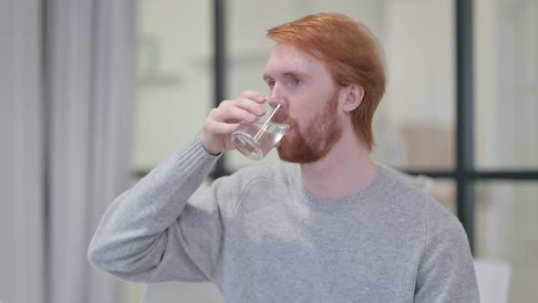 Portrait of Young Redhead Man Drinking Water