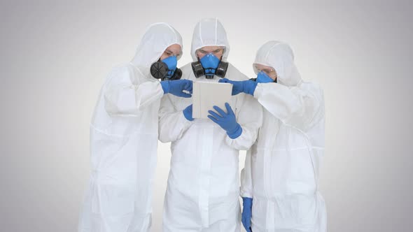 Doctors or Scientists Wearing Hazmat Suits Working Together on Digital Tablet on Gradient Background