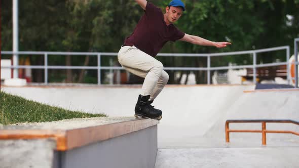 Aggressive Inline Roller Skater Doing Tricks in Concrete Skatepark Outdoors with Beautiful