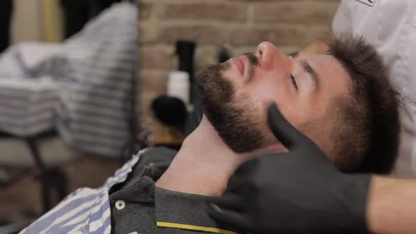 Client with Black Beard During Beard Shaving in Barber Shop. Groom, Masculine