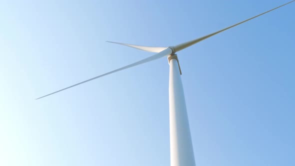Wind turbine rotating on clear blue sky Local eco friendly powerful converter farm generating energy