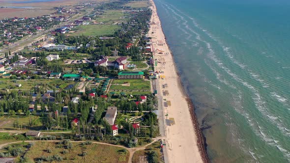 Beautiful flight in summer over the beach. People are resting near the sea.