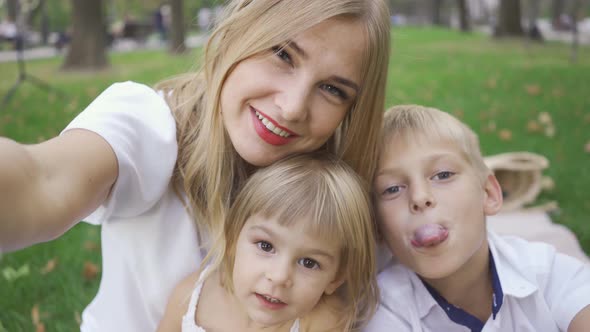 Pretty Caucasian Woman and Her Two Kids Looking at Camera Smiling