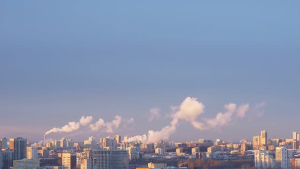 City Pipes Emit Steam Into the Atmosphere Against the City Skyline