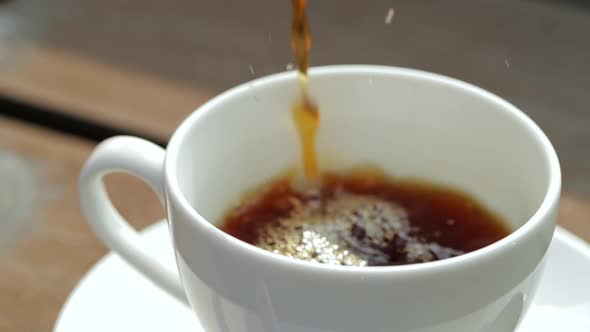 Hot Coffee poring into a cup with slow motion 