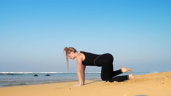 Attractive Young Woman Exercises at Endless Blue Ocean