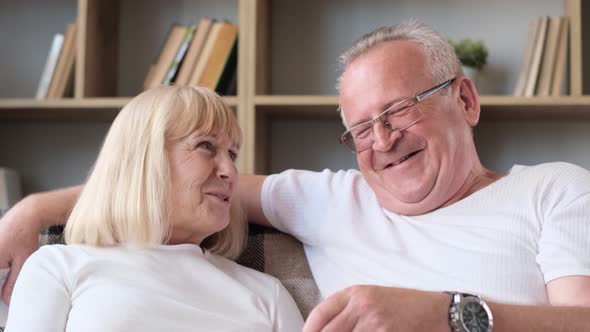 Happy Elderly Married Couple Watching Tv Sitting on Sofa Old Couple Eating Popcorn and Laughing