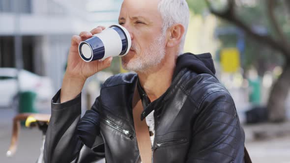 Caucasian man out and about in the city street drinking a coffee