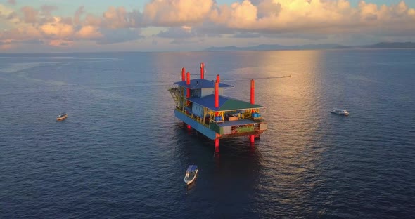 Aerial flight at stunning sunset over oil platform in ocean in Mabul, Malaysia