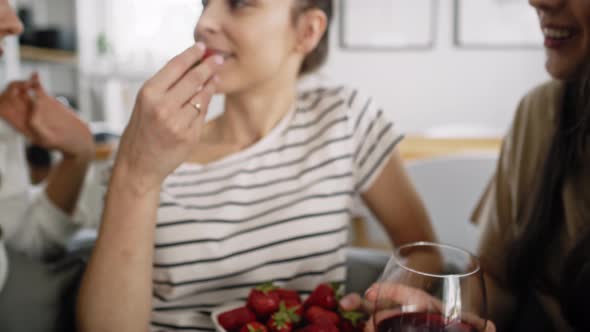 Zoom out video of friends chatting and eating seasonal strawberries