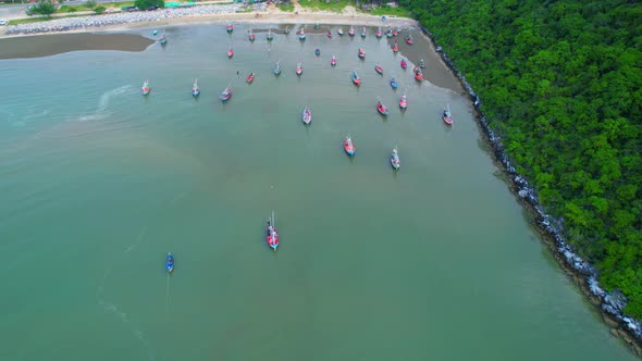 Many fishing boats on the coast beside the mountains, beautiful sea area in Thailand.