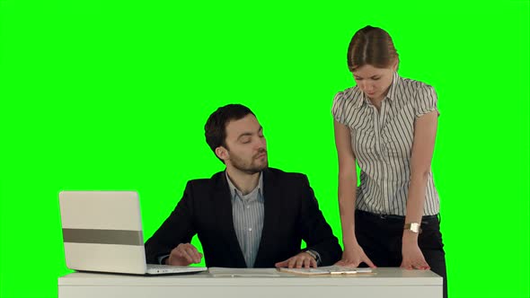 Business People Having Meeting Around Table with Laptop on Laptop on a Green Screen, Chroma Key