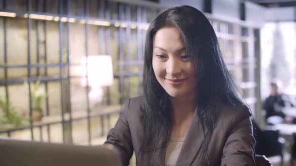 Smiling Businesswoman Working in Cafe